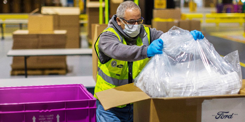 A Ford employee packages masks for shipping